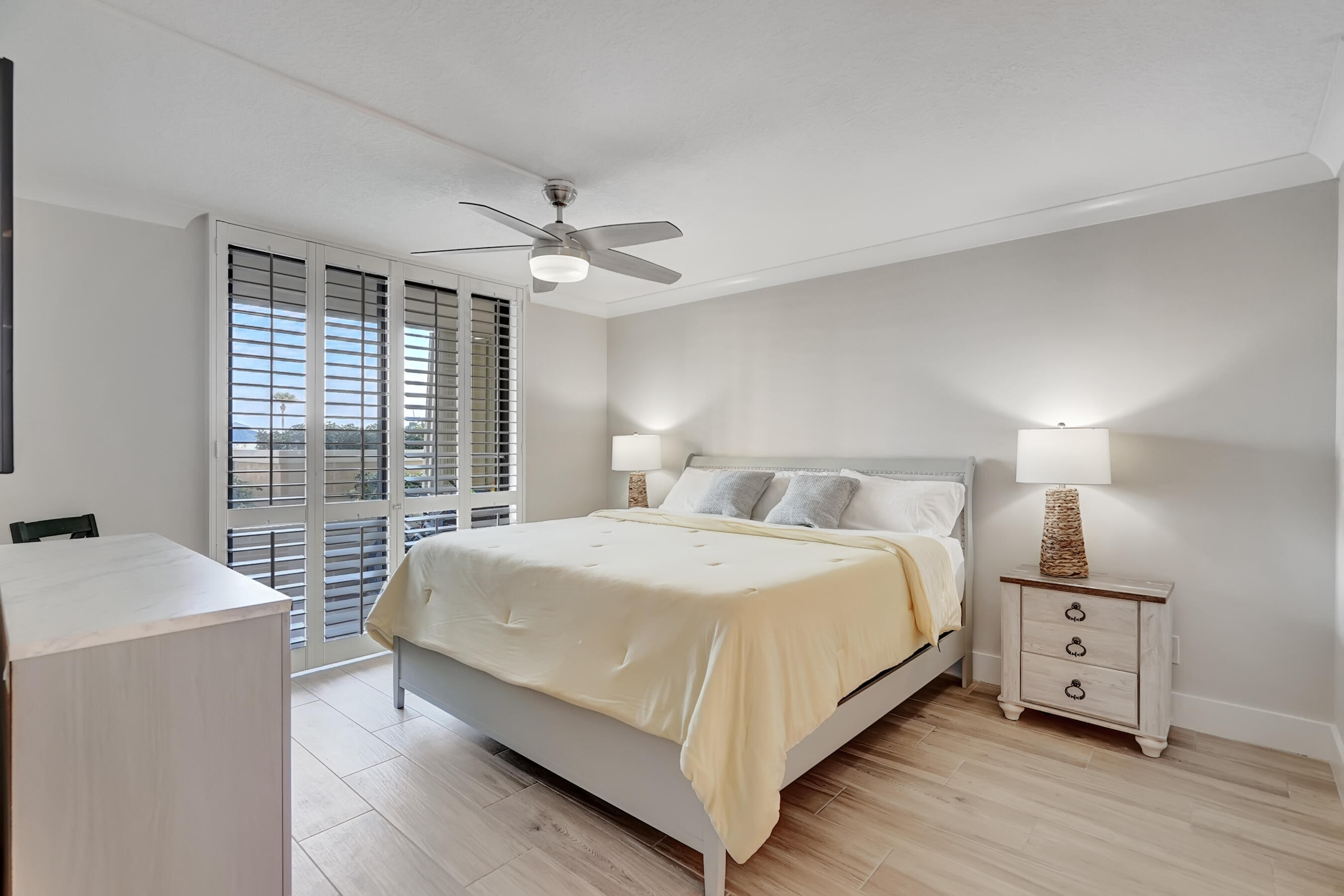100 Ocean Trail Way, Unit 108 Jupiter, FL 33477 - Photo 15 of 30 a large bedroom with a bed and a chandelier
