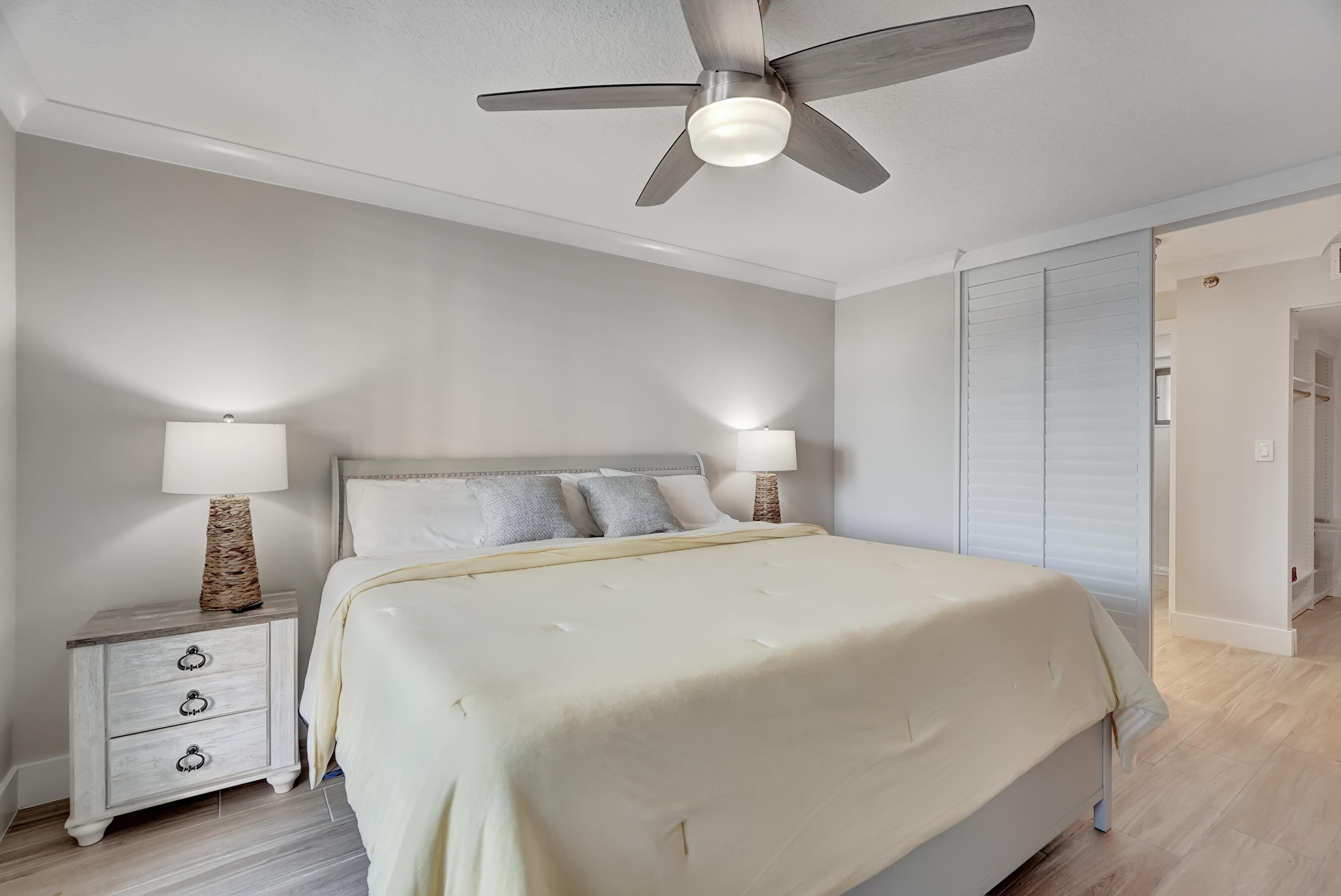 100 Ocean Trail Way, Unit 108 Jupiter, FL 33477 - Photo 16 of 30 a bedroom with a large bed and a chandelier
