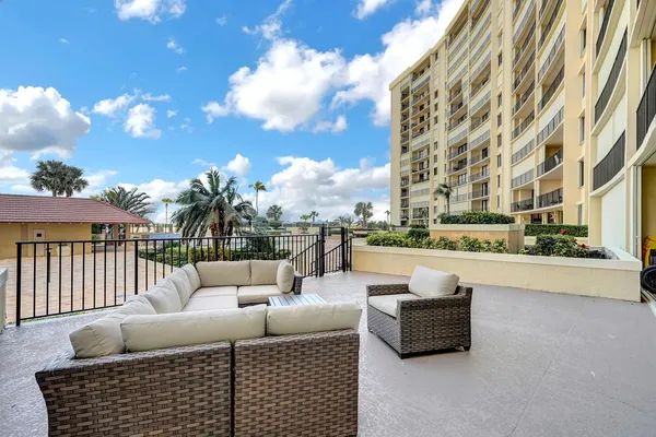 a roof deck with couches and potted plants