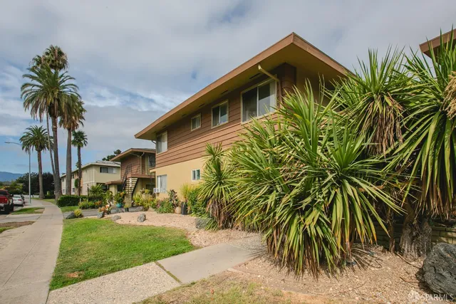 a front view of multiple houses with yard