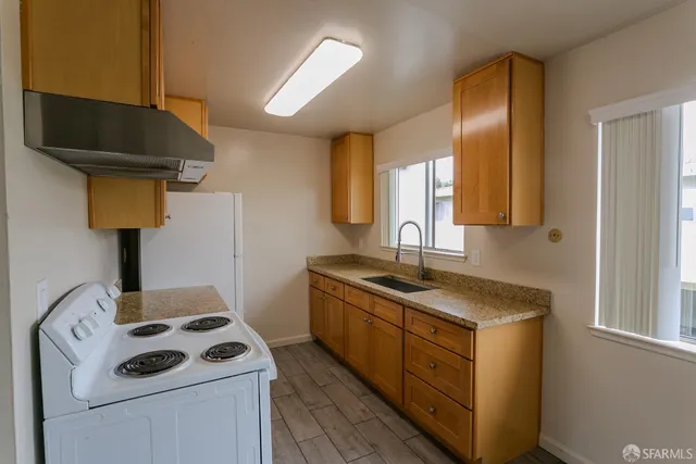 a kitchen with a sink stove and cabinets