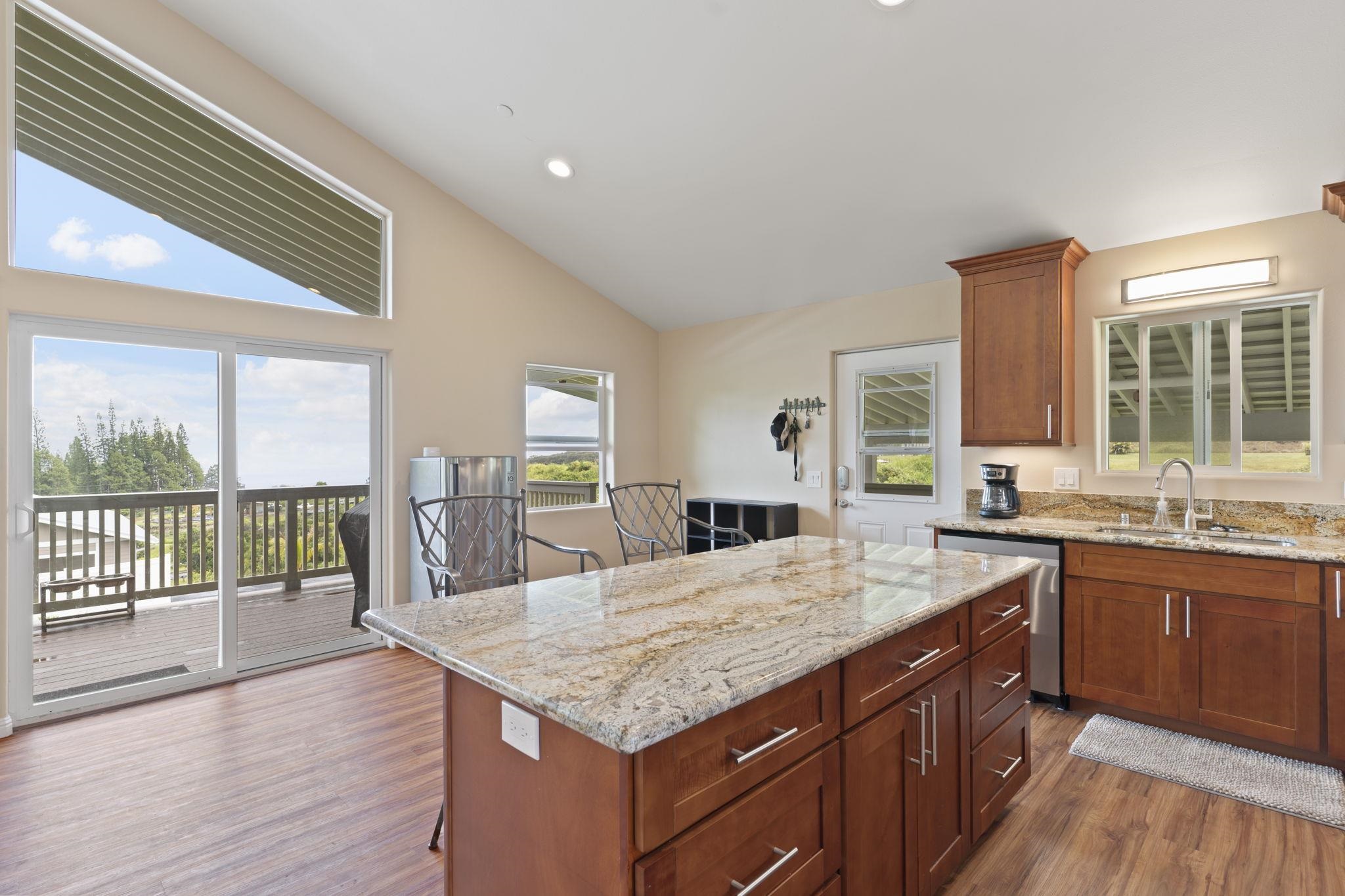 752 Awalau Road, Unit B Haiku, HI 96708 - Photo 13 of 30 a kitchen with granite countertop a stove a sink and wooden cabinets