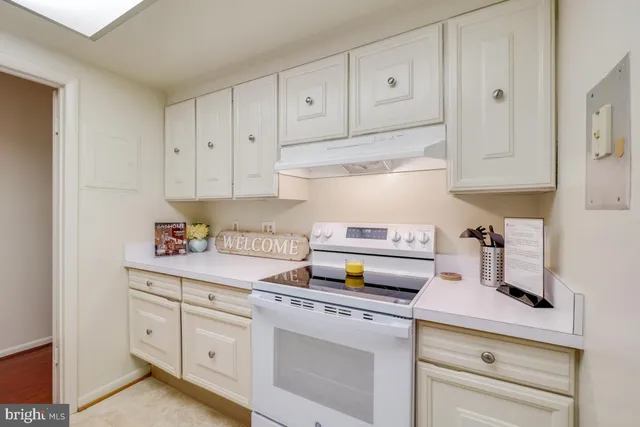 a kitchen with white cabinets and white appliances