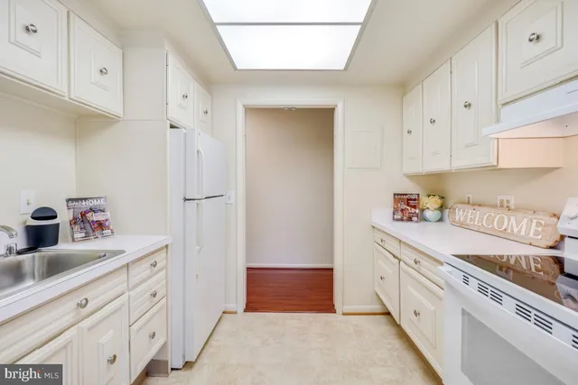 a kitchen with white cabinets and white appliances