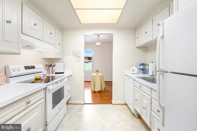 a kitchen with white cabinets and white appliances