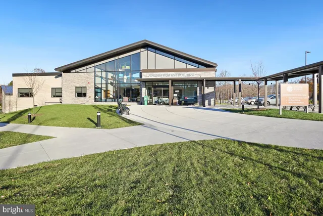 a front view of a house with a yard and potted plants