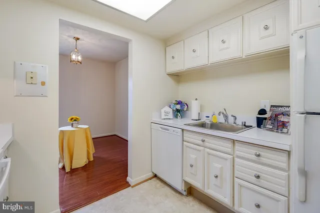 a kitchen with white cabinets and sink