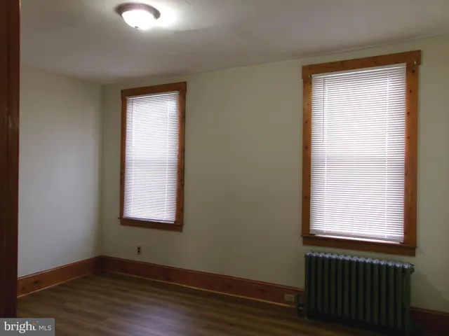 a bathroom with a toilet a window and a potted plant