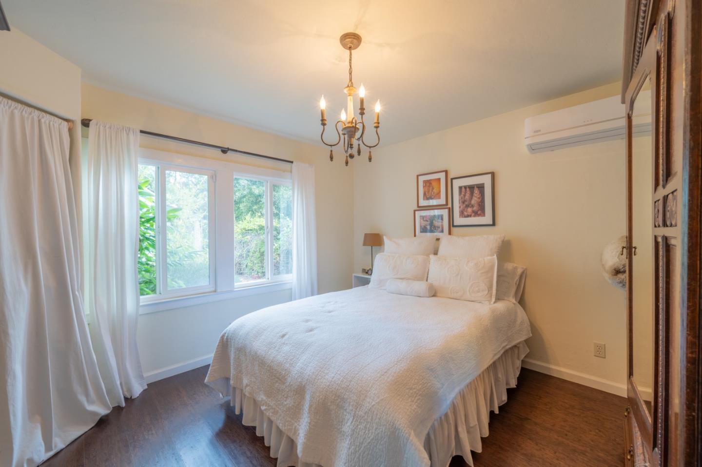 26208 Atherton Drive Carmel, CA 93923 - Photo 12 of 22 a bedroom with a large bed and a chandelier