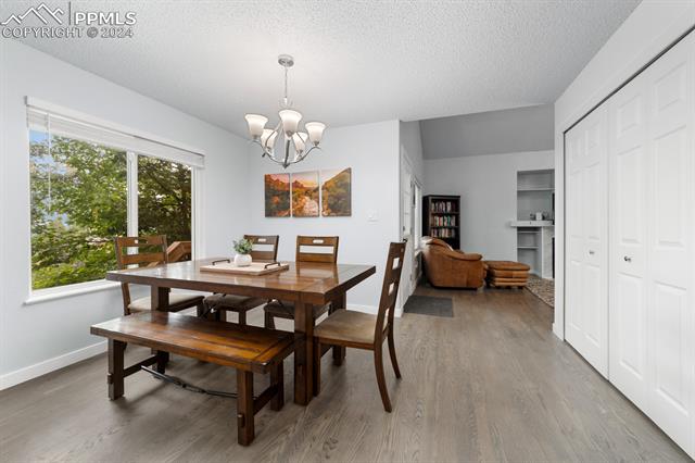 7730 Julynn Road Colorado Springs, CO 80919 - Photo 10 of 48 Dining area with a chandelier, a textured ceiling, and hardwood / wood-style floors