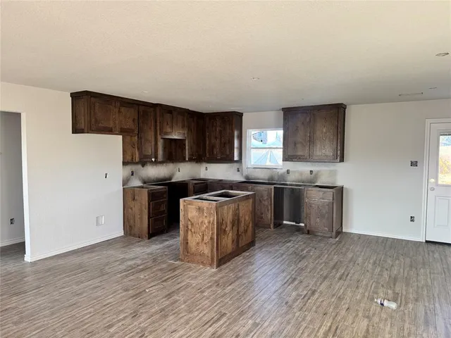 a kitchen with stainless steel appliances wooden floors and white cabinets