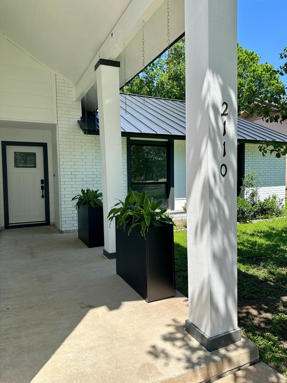 2110 Magazine Street Austin, TX 78727 - Photo 4 of 31 Covered porch entrance featuring a white brick facade and a white main entry door with decorative glass