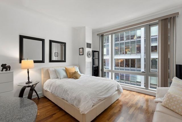 a bedroom with a bed and a large window