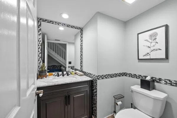 a bathroom with a sink mirror vanity and toilet