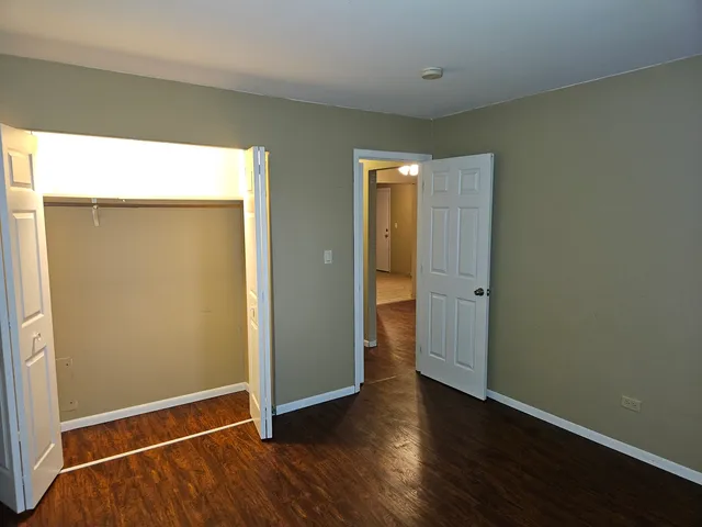 an empty room with wooden floor and closet