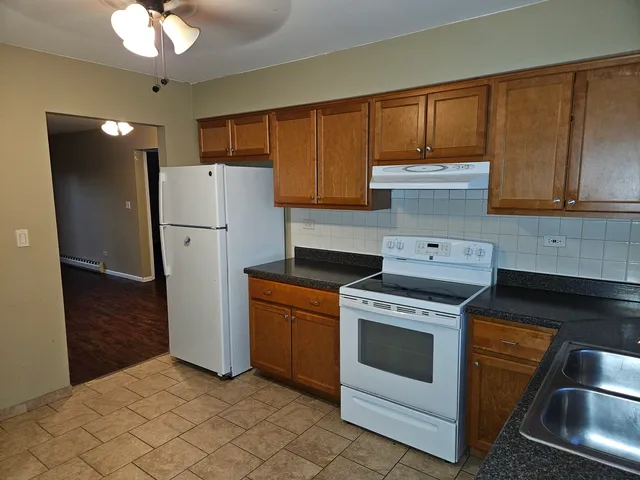 a kitchen with a refrigerator sink and cabinets