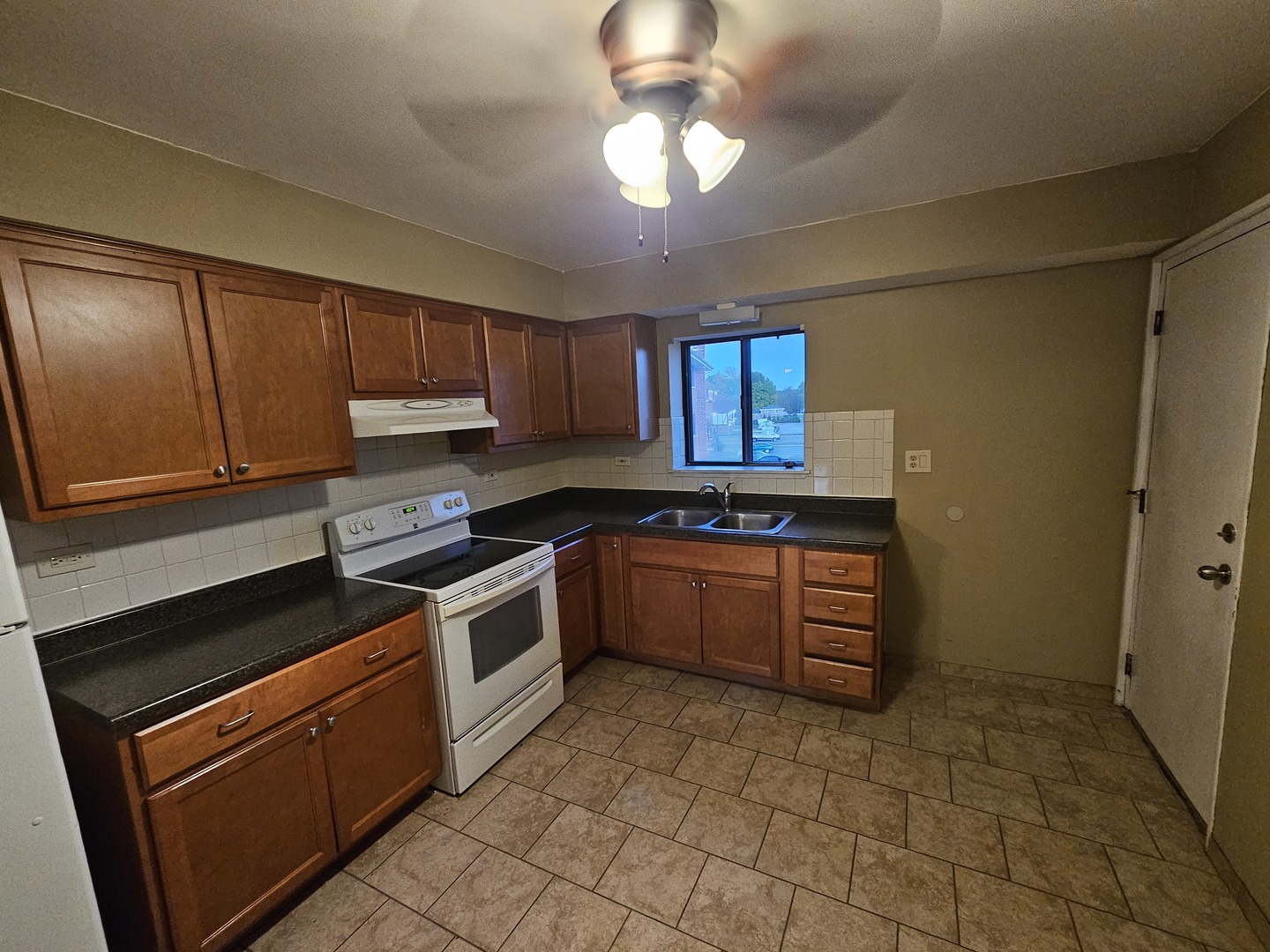 737 Lippert Lane, Unit 2N Glendale Heights, IL 60139 - Photo 6 of 15 a kitchen with stainless steel appliances granite countertop a stove a sink and a refrigerator