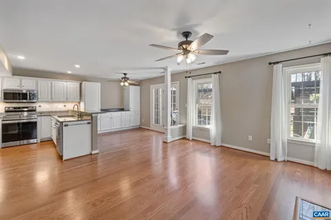 a view of kitchen with granite countertop stainless steel appliances and wooden floor