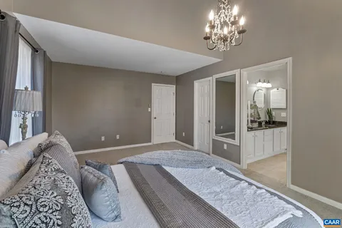 a bedroom with a large bed and a chandelier