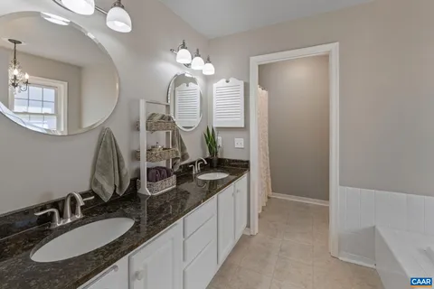 a bathroom with a granite countertop sink a light fixture and a mirror