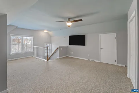 an empty room with windows and fireplace