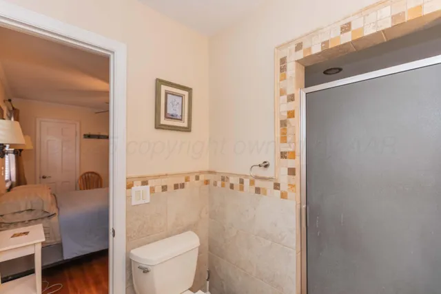 a bathroom with a toilet and a shower