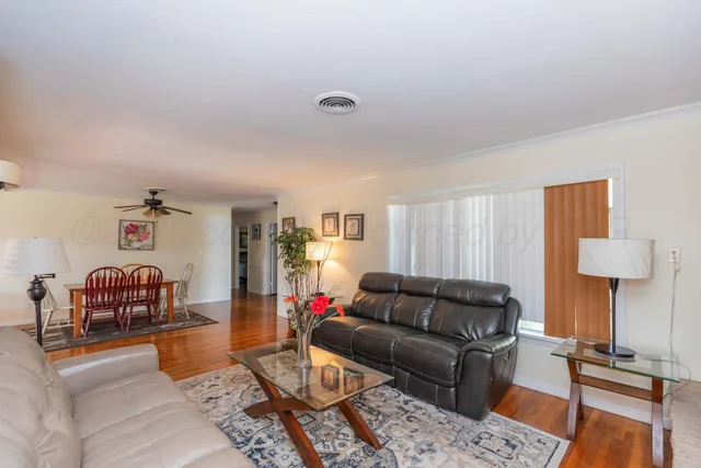 a living room with furniture and a wooden floor