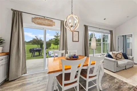 a dining room with furniture a chandelier and wooden floor