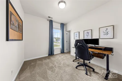 a view of a workspace with furniture and a window
