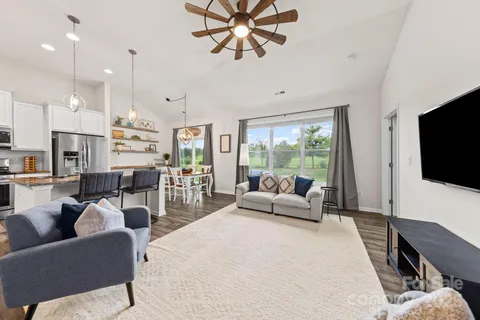 a living room with furniture a flat screen tv and a large window