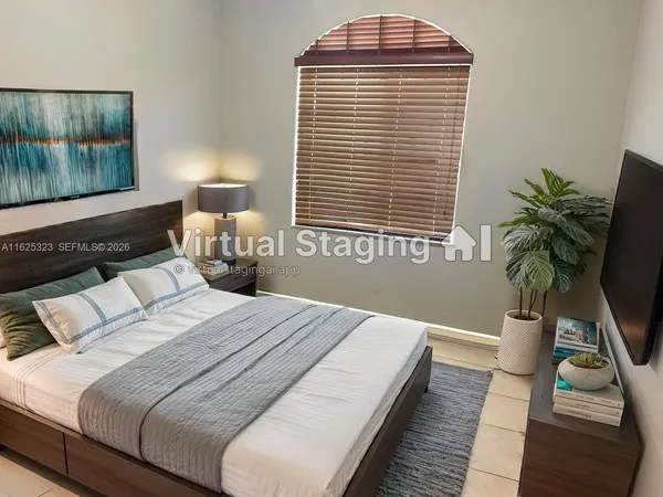 a bedroom with bed and a potted plant