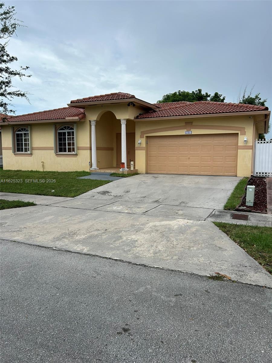 12414 Southwest 213th Street Miami, FL 33177 - Photo 7 of 15 a front view of a house with a yard and garage