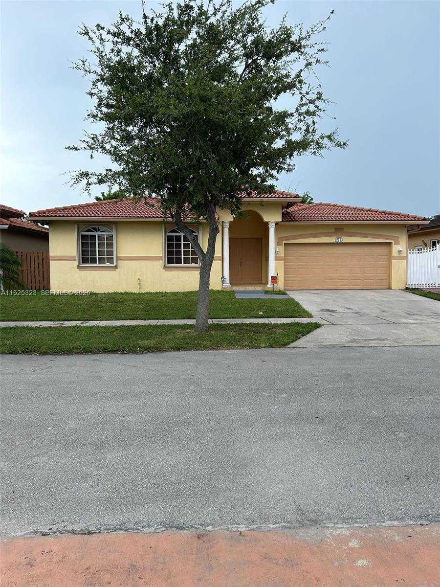 12414 Southwest 213th Street Miami, FL 33177 - Photo 8 of 15 a front view of a house with a yard and garage