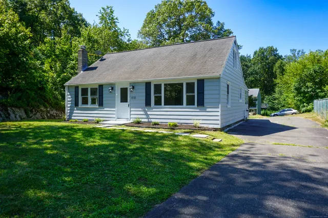 a front view of a house with yard and green space