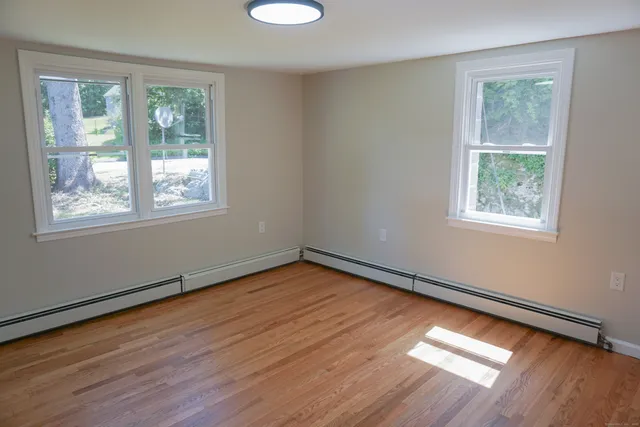 a view of a room with wooden floor and windows