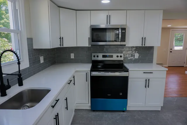 a kitchen with granite countertop a sink and a stove top oven