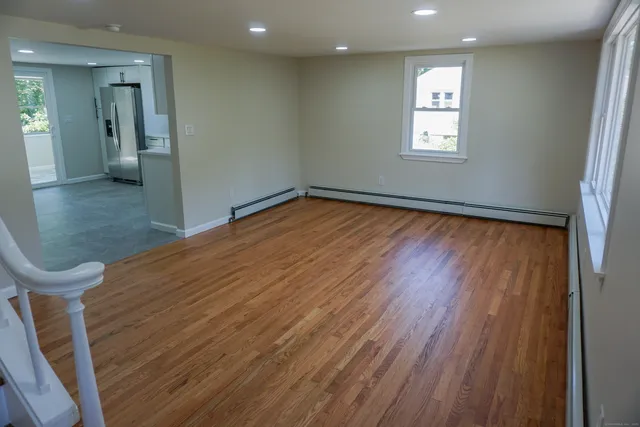a view of a room with wooden floor and windows