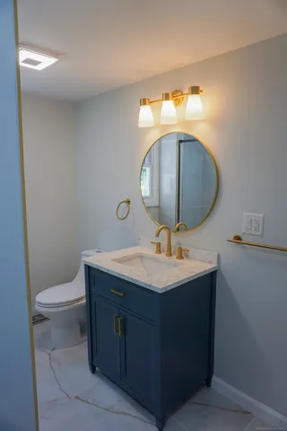 a bathroom with a toilet sink and mirror