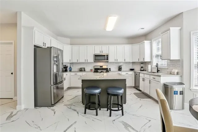 a kitchen with stainless steel appliances granite countertop a refrigerator sink and stove