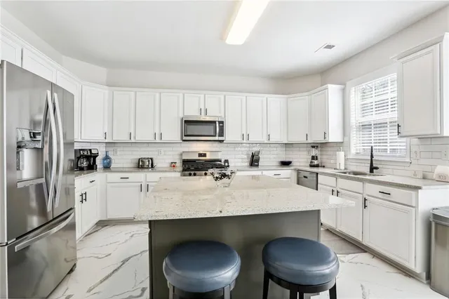 a kitchen with stainless steel appliances a white refrigerator sink and cabinets