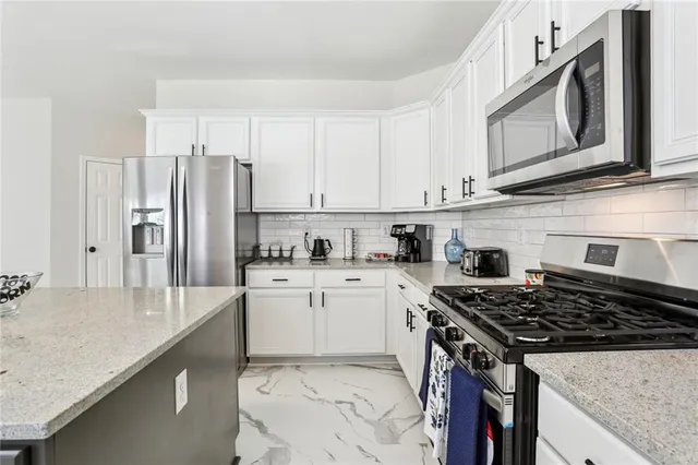 a kitchen with granite countertop a sink stove and refrigerator