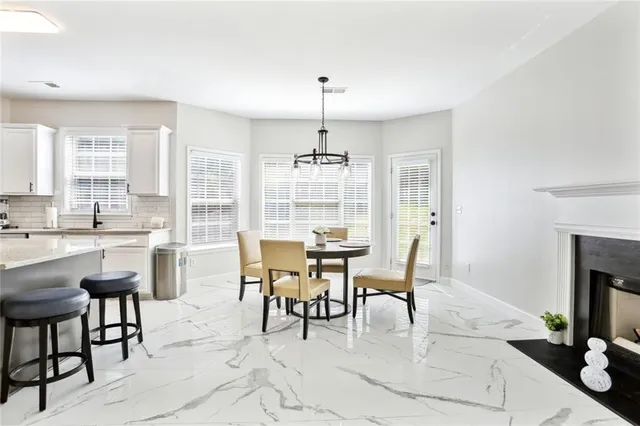 a dining room with furniture a chandelier and fireplace
