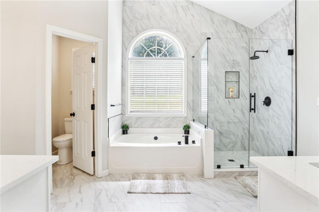 5161 Madison Green Drive Southwest Mableton, GA 30126 - Photo 24 of 40 a bathroom with a tub a toilet and a window
