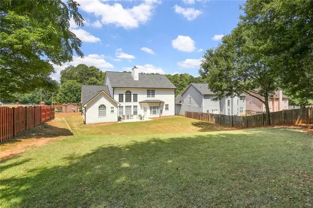 a front view of a house with a big yard and a large tree