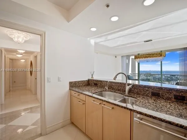 a kitchen with granite countertop a refrigerator and a sink