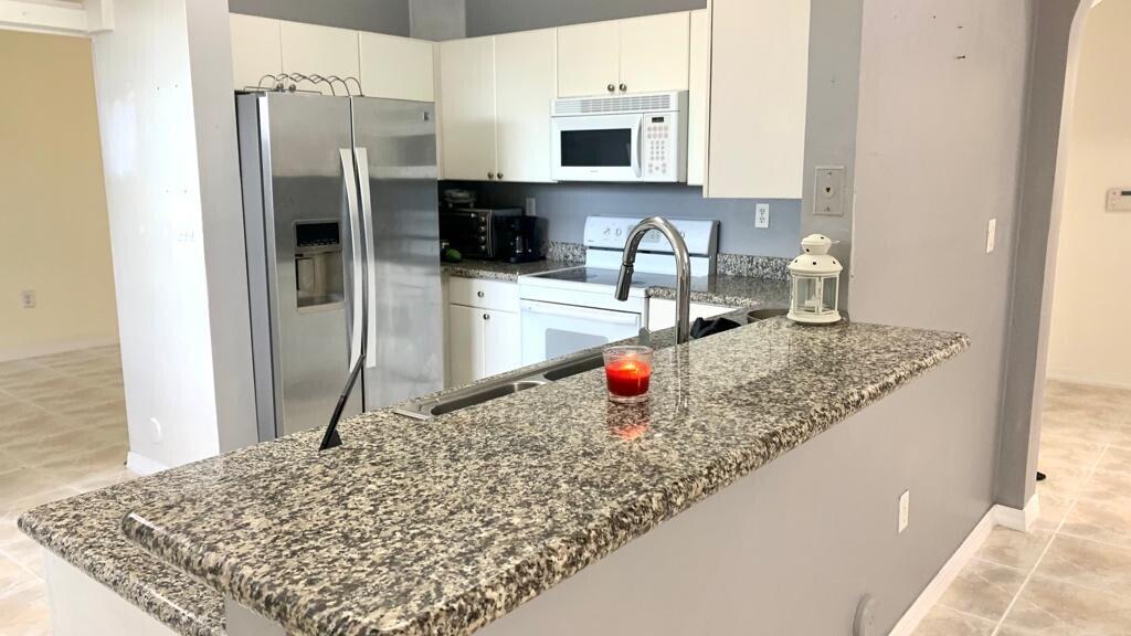 15809 Southwest 60th Terrace Miami, FL 33193 - Photo 6 of 20 a kitchen with stainless steel appliances granite countertop a sink refrigerator and microwave