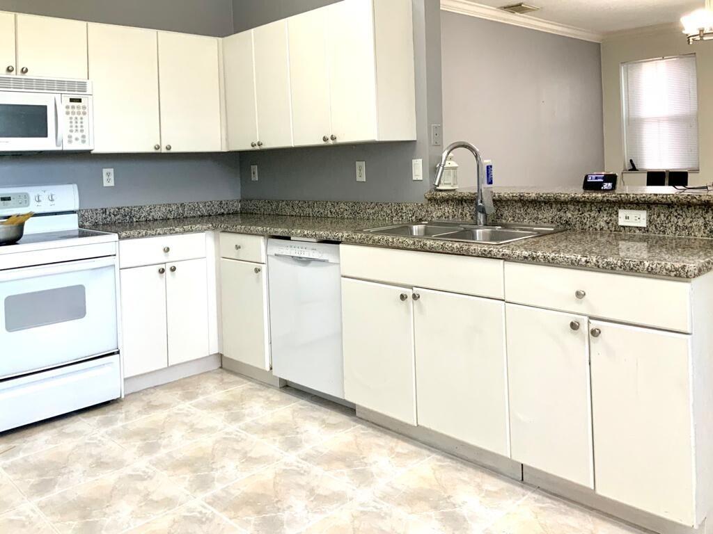 15809 Southwest 60th Terrace Miami, FL 33193 - Photo 7 of 20 a kitchen with granite countertop a sink and white cabinets