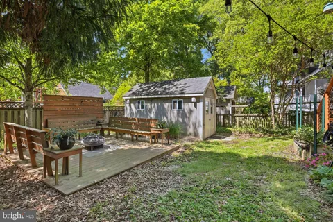 a view of a patio with table and chairs and wooden fence