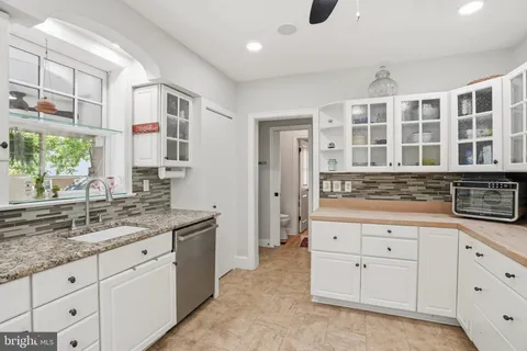 a spacious bathroom with a granite countertop sink and a mirror