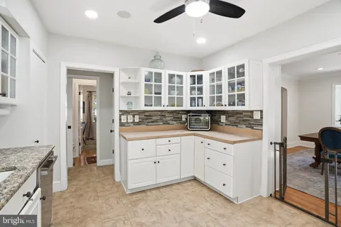a view of kitchen with granite countertop cabinets and refrigerator